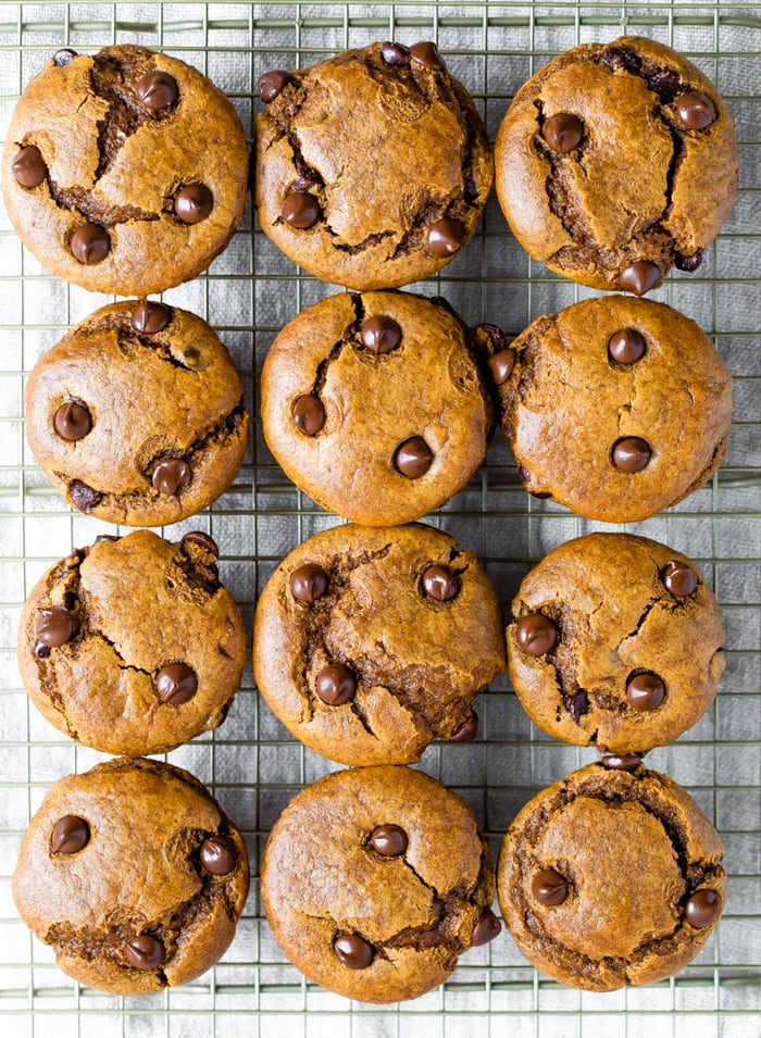 An overhead shot of a cooling rack with 12 flourless pumpkin muffins on top.