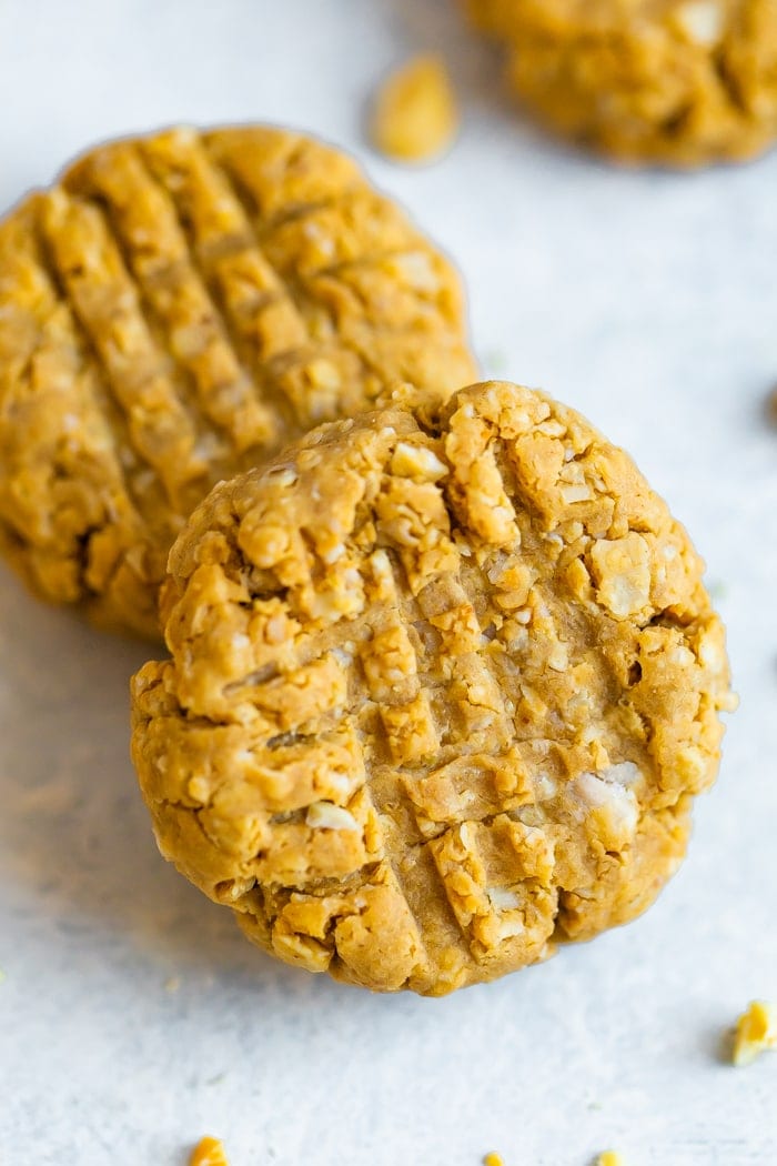 Two peanut butter protein cookies, one laying on top of the other. 