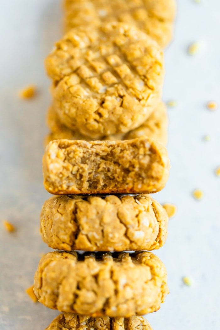 Stack of peanut butter protein cookies laying on a white surface.