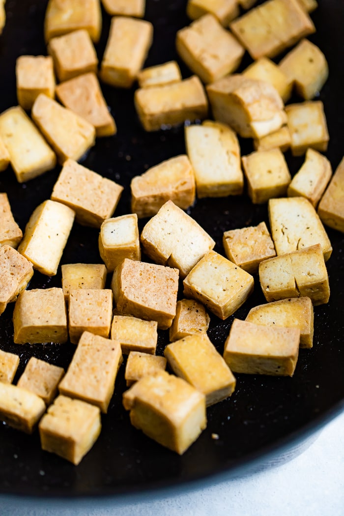 Baked cubes of tofu on a baking sheet.