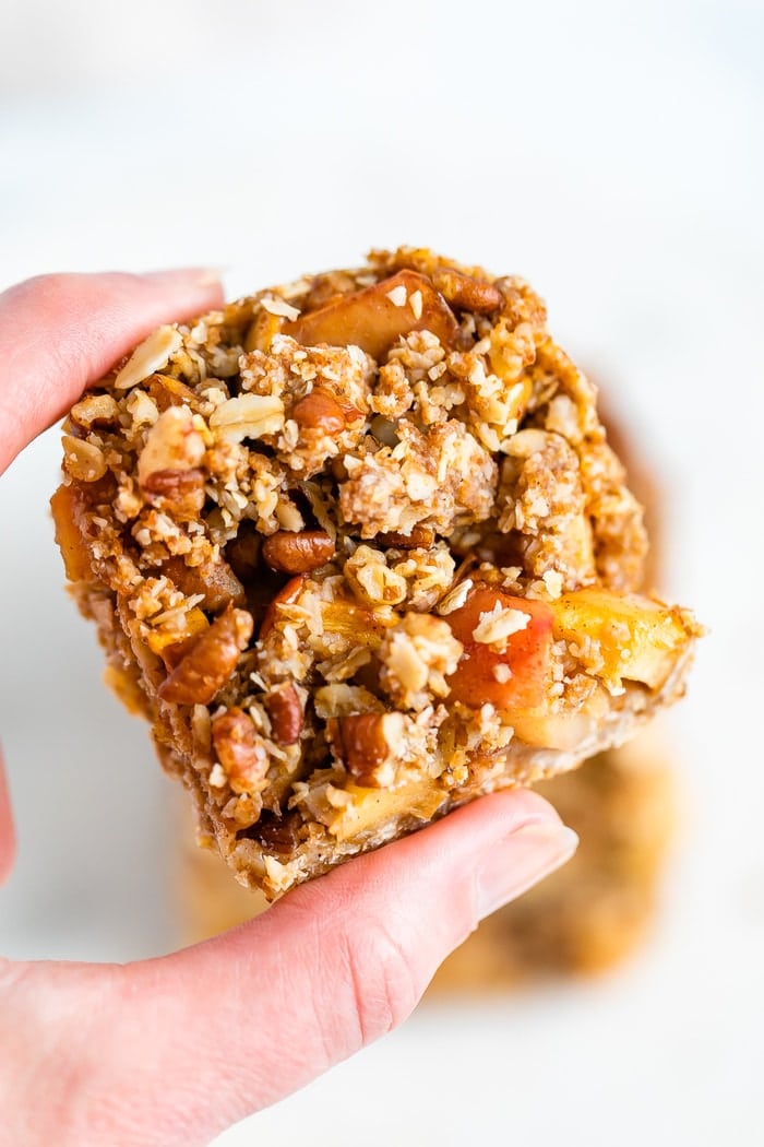 Hand holding an apple crumble bar.