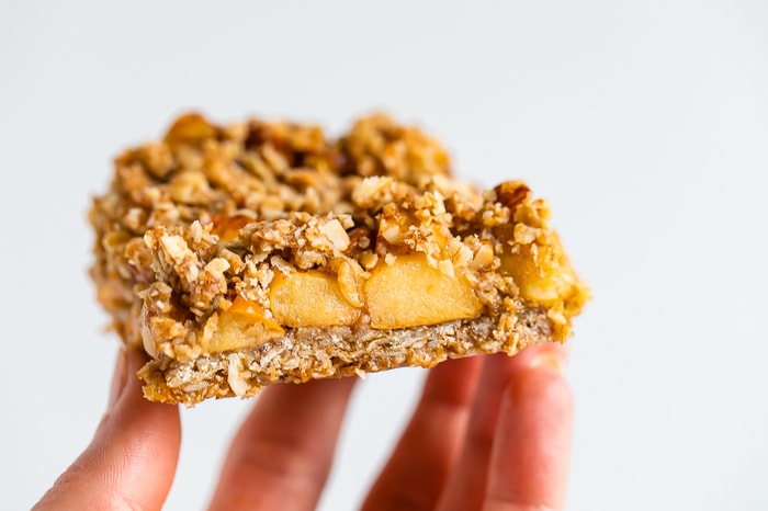 Hand holding an apple crumble bar.