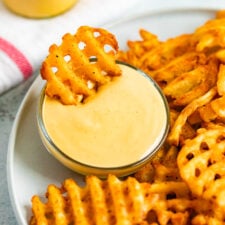 Waffle fry being dipped into homemade Chick-Fil-A Sauce.