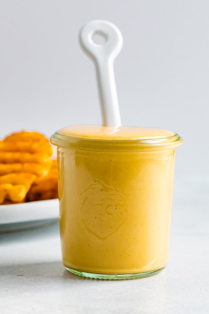 Jar filled with homemade Chick-Fil-A Sauce and a white spoon in it.