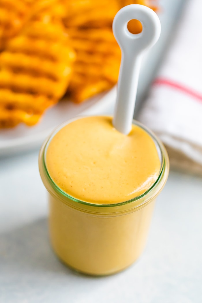 Jar filled with homemade Chick-Fil-A Sauce and a white spoon in it.