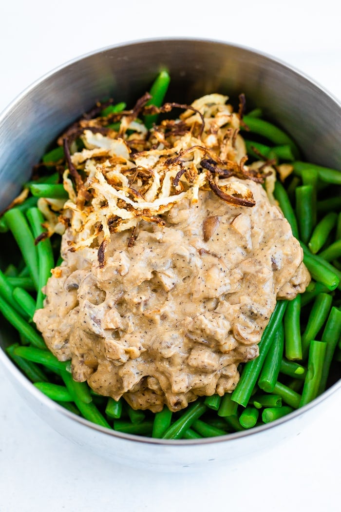 Mixing bowl with green beans, crispy onions, and a vegan, creamy mushroom sauce.