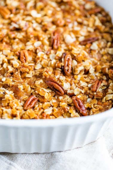 Baking dish with sweet potato baked oatmeal topped with pecans.