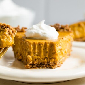 Slice of vegan pumpkin pie topped with whipped cream.