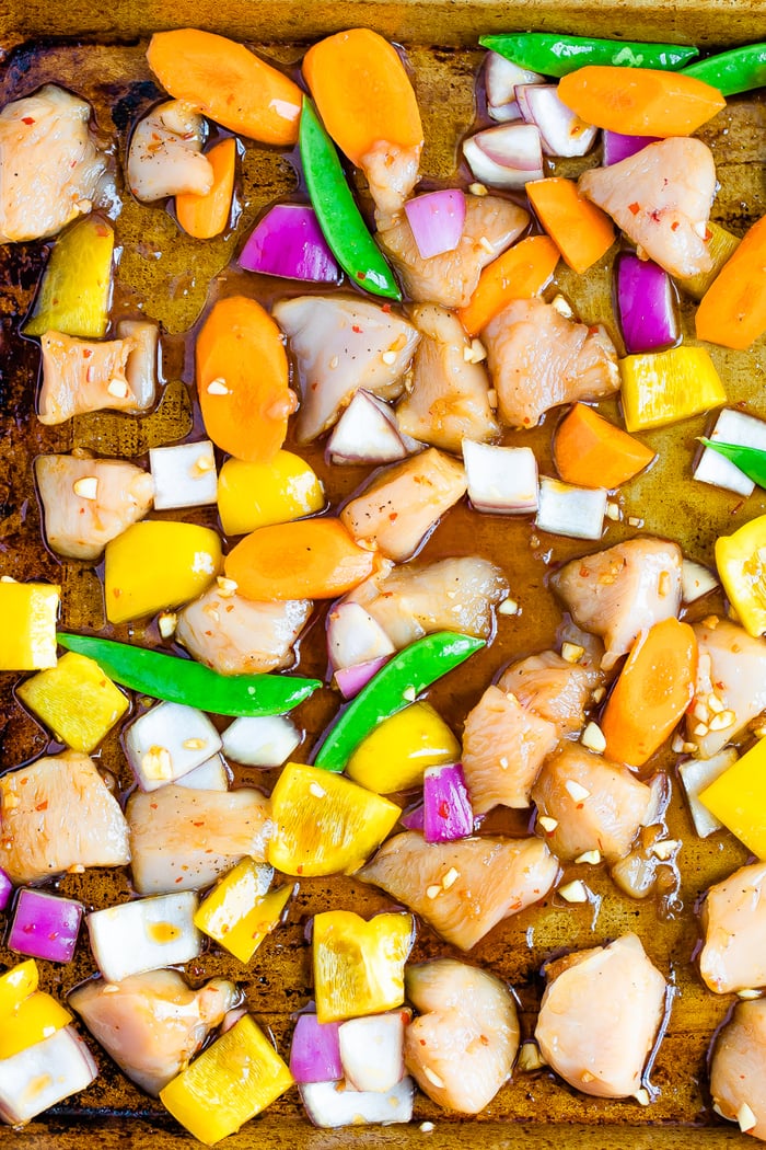 Asian chicken sheet pan meal with veggies before being baked.