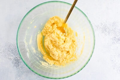 Gluten-free sugar cookies dough in a bowl with a gold spoon.