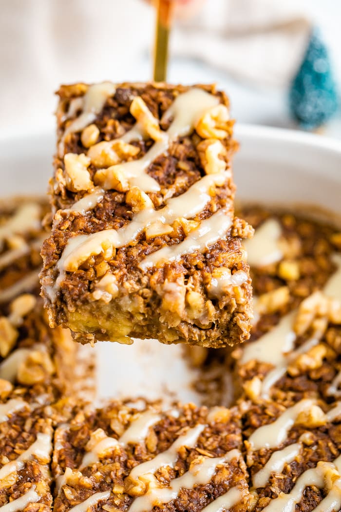 Spatula lifting a slice of gingerbread baked oatmeal out of a baking dish.