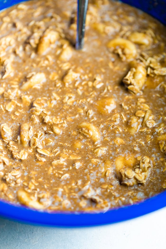 Mixing bowl with the ingredients for gingerbread baked oatmeal being mixed.