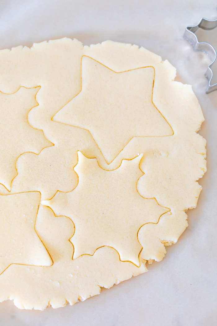 Sugar cookies dough with cut out shapes.