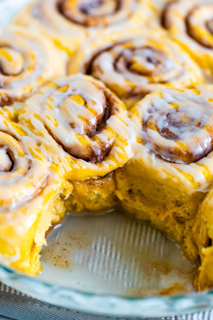 Pumpkin cinnamon rolls drizzled with frosting.