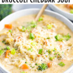 Bowl of broccoli cheddar soup with a gold spoon in the bowl.