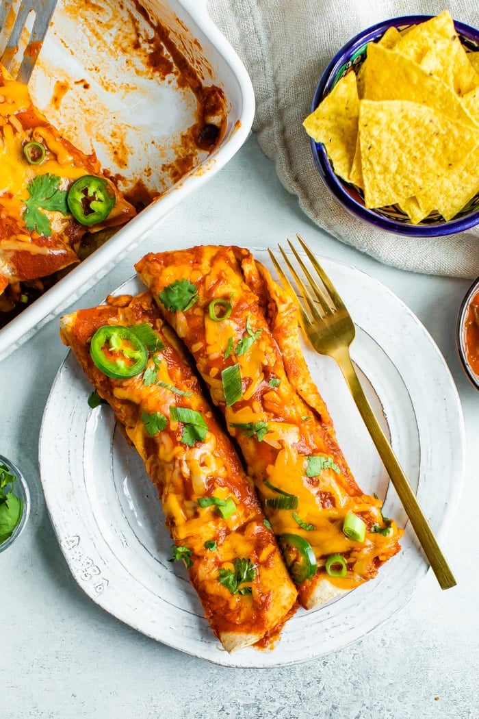 Two chicken enchiladas on a plate.