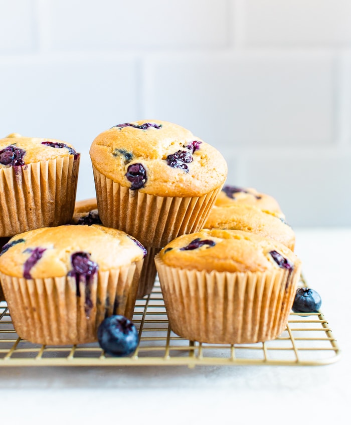 Blueberry muffins stacked on a cooling rack.