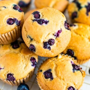 Cluster of blueberry muffins on a gold cooling rack.