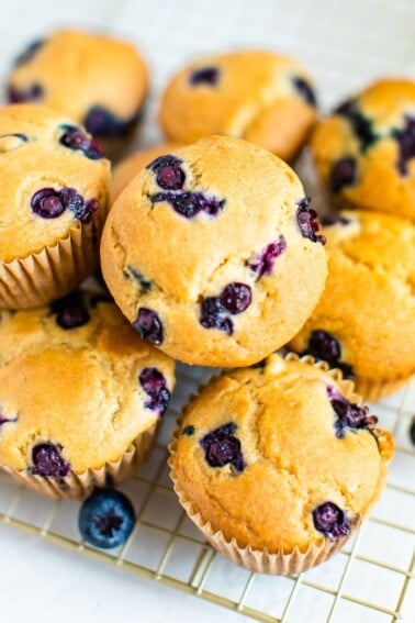 Cluster of blueberry muffins on a gold cooling rack.