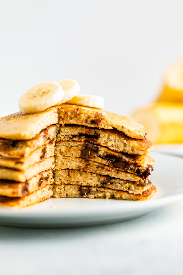 Stack of chocolate chip Greek yogurt pancakes with a slice taken out of the stack.