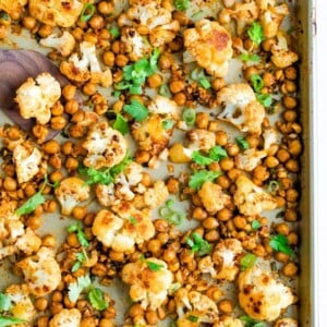 Roasted cauliflower and chickpeas on a sheet pan topped with cilantro.