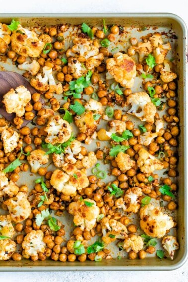 Roasted cauliflower and chickpeas on a sheet pan topped with cilantro.