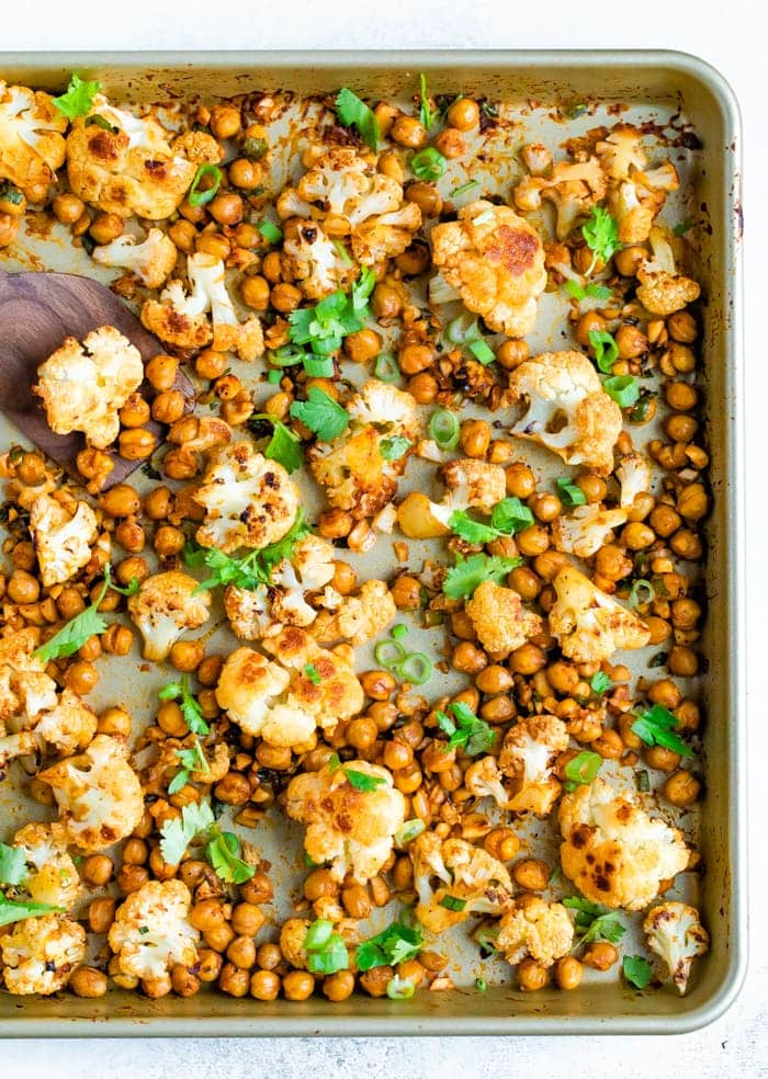 Sheet pan with roasted cauliflower and chickpeas topped with cilantro.