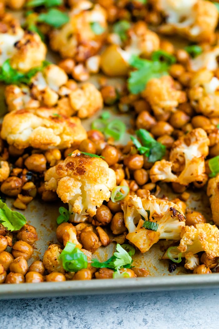 Roasted cauliflower and chickpeas on a sheet pan topped with cilantro.