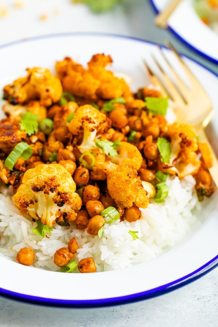 Roasted spicy cauliflower and chickpeas served over rice and topped with cilantro.