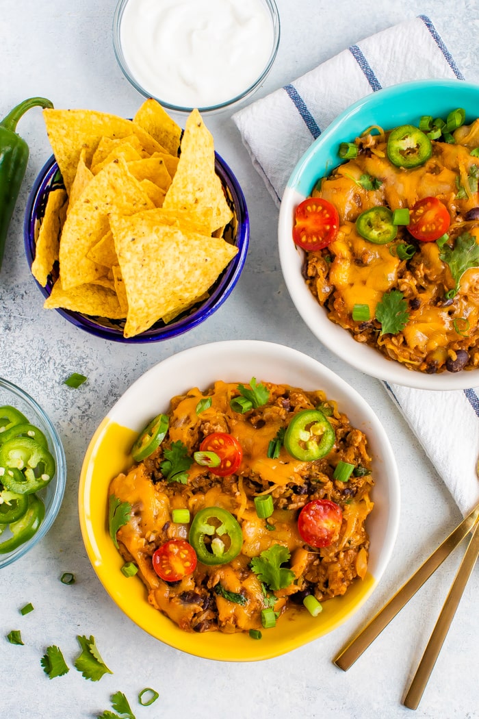 Two bowls of spaghetti squash taco bake and a bowl of tortilla chips beside them.