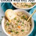 Bowl full of creamy chicken wild rice soup and served with fresh thyme and bread.