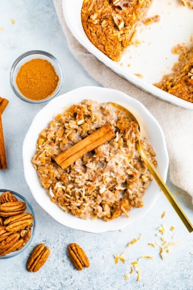 Bowl full of chai baked oatmeal topped with almond milk and a cinnamon stick.