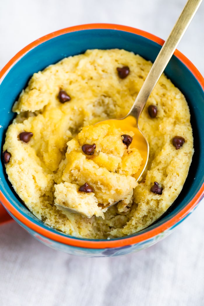 Chocolate Chip Mug Cake in a mug with a spoon scooping a bite.