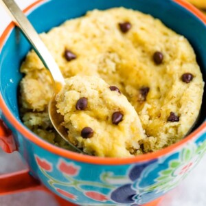 Chocolate Chip Mug Cake in a mug with a spoon scooping a bite.