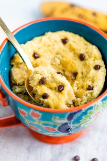 Chocolate Chip Mug Cake in a mug with a spoon scooping a bite.