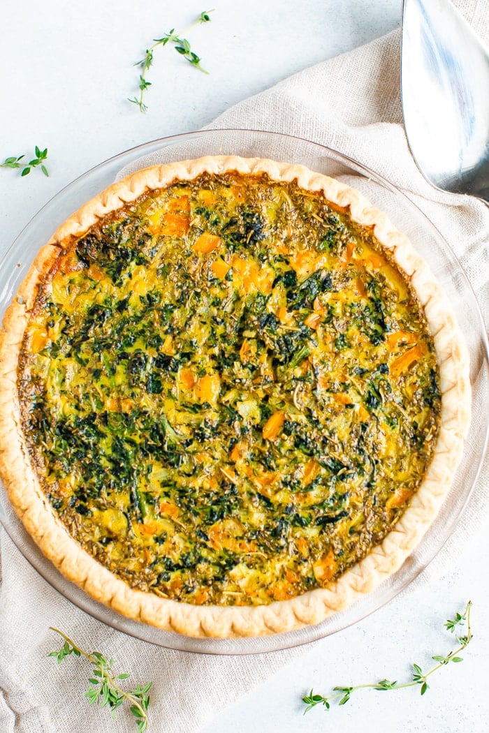 Spinach quiche with bell peppers surrounded by thyme.