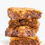 Stack of four gooey blondies with chocolate chips.