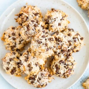 Plate of almond coconut cookies make with chopped almond, coconut flakes and chocolate chips.