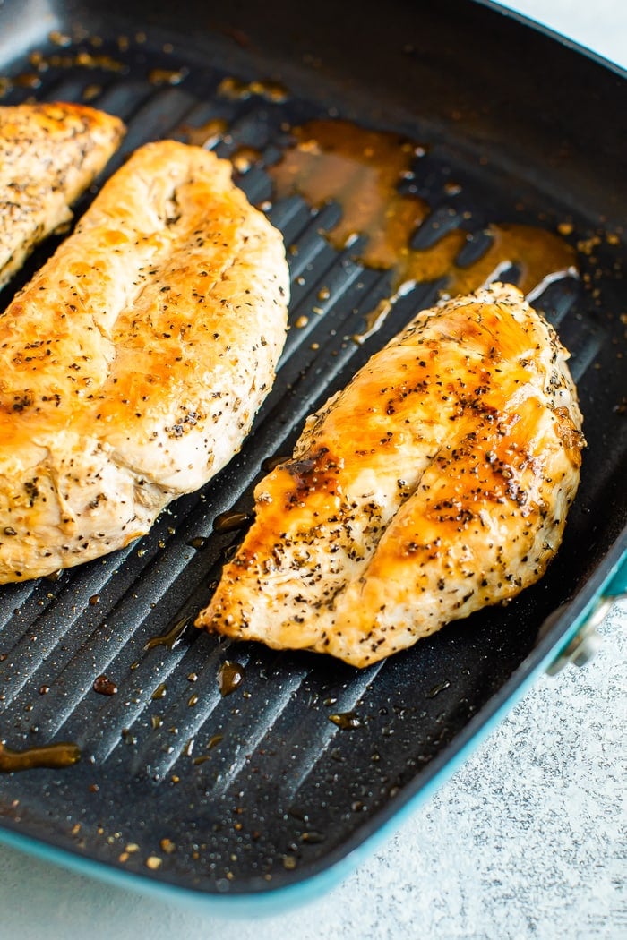 Seasoned chicken being grilled in a grill stove pan.