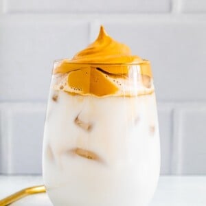Glass of iced non-diary milk topped with coffee foam.