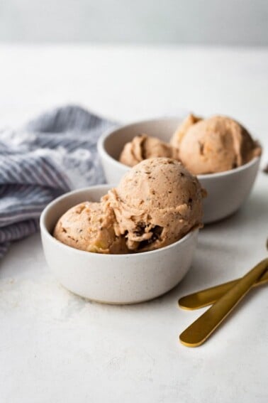 Two bowls with scoops of chocolate banana ice cream.