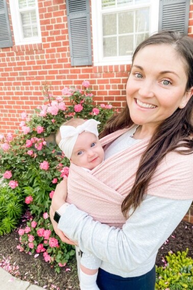 Mom outside with 5 month old baby in a pink Solly Baby wrap.