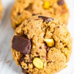 Two cookies studded with pistachios and dark chocolate chunks.