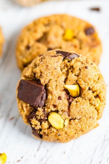 Two cookies studded with pistachios and dark chocolate chunks.