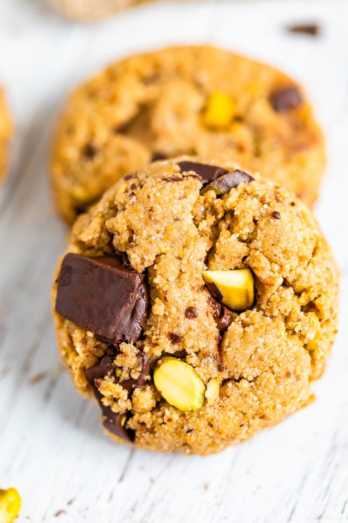 Two cookies studded with pistachios and dark chocolate chunks.