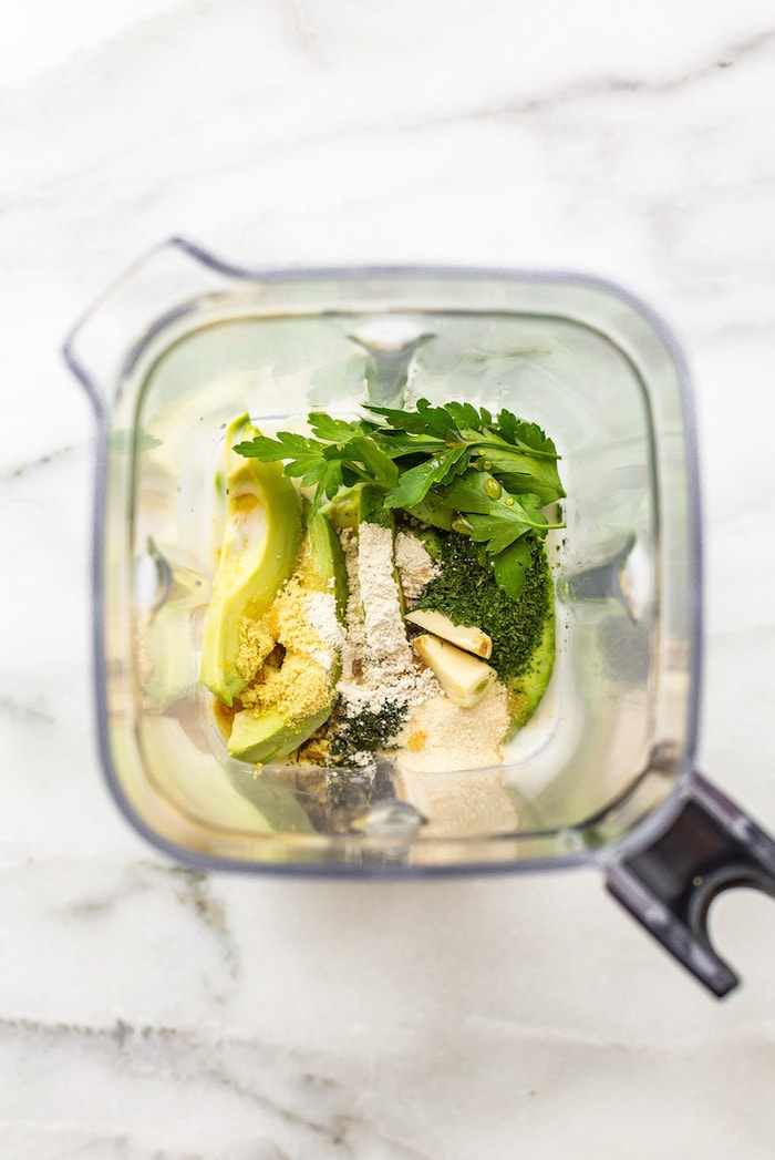 Blender cup with ingredients for avocado ranch dressing.