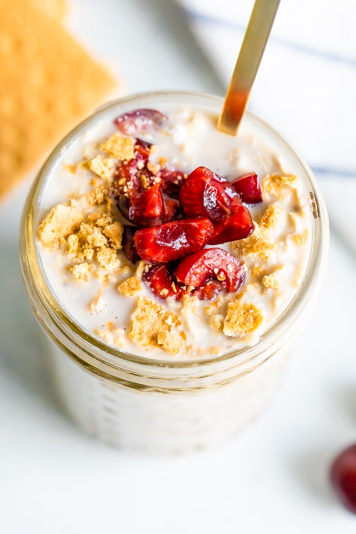 Overhead shot of cherry cheesecake overnight oats in a mason jar.