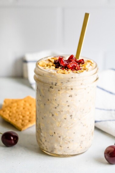 Straight on shot of cherry cheesecake overnight oats in a mason jar.