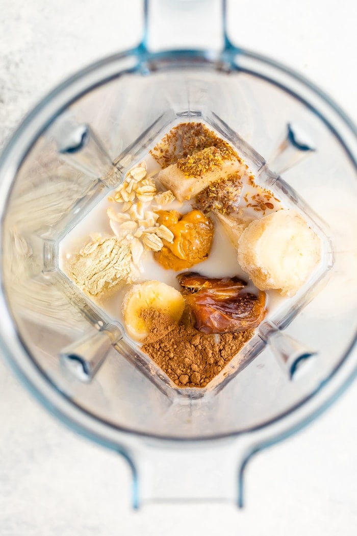 Ingredients for a chocolate banana peanut butter lactation smoothie in a blender.