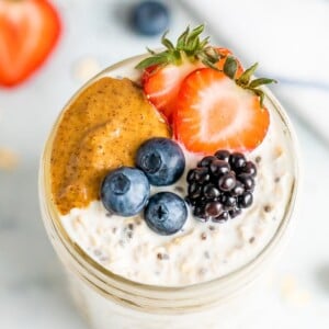 Overhead shot of basic overnight oats with berries and peanut butter on top.